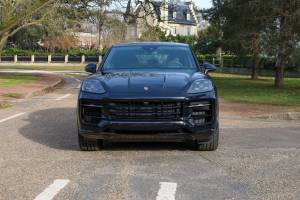 SUV noir moderne photographié dans un studio sombre, au design sportif et élégant