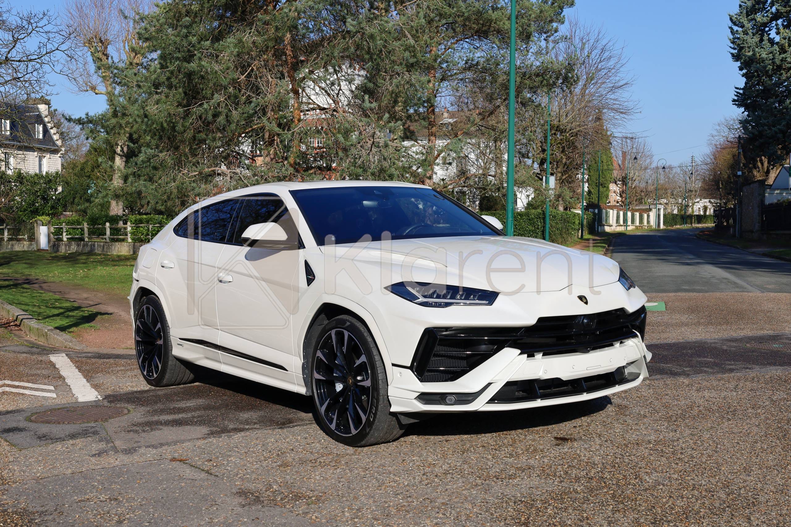 Vue avant d’un SUV blanc sportif photographié dans un parking lumineux, voiture au design agressif et élégant