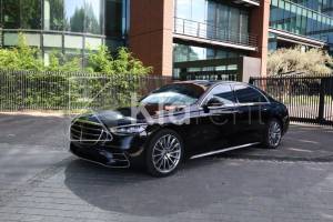 Berline noire de luxe photographiée devant un bâtiment, berline au design élégant et raffiné