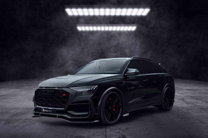 SUV noir sportif photographié dans un studio sombre, au design agressif et élégant
