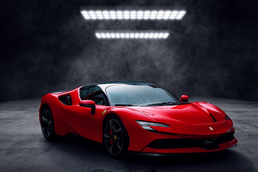 Vue avant d’une voiture de sport rouge photographiée dans un studio sombre, au design aérodynamique et agressif