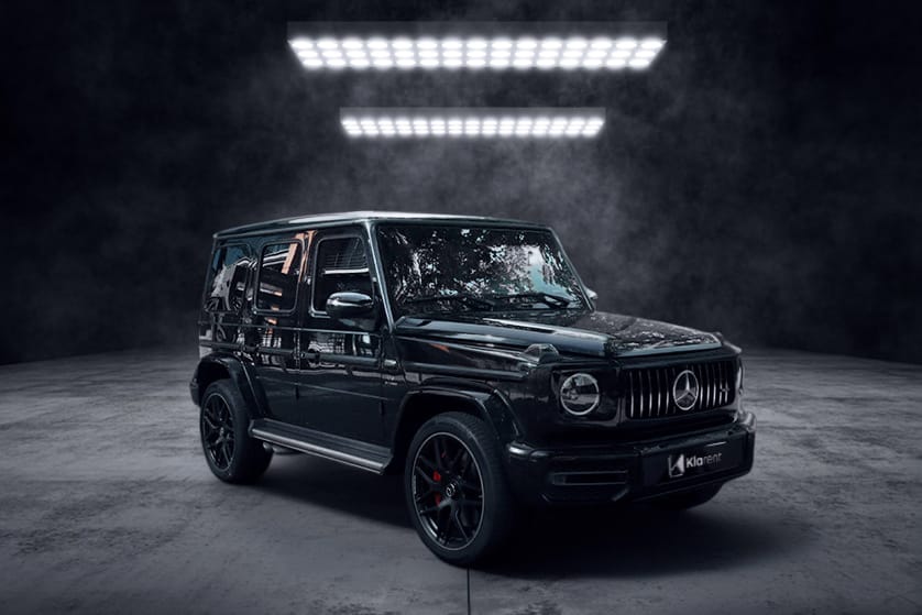 Mercedes G 63 AMG – Collection Évasion SUV noir haut de gamme photographié dans un studio sombre, au design robuste et luxueux