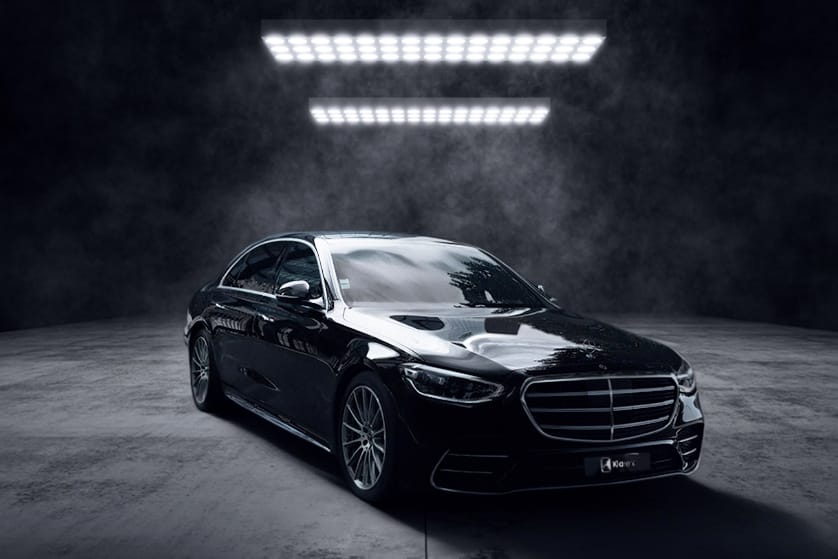 Berline noire de luxe photographiée dans un studio sombre, au design élégant et raffiné