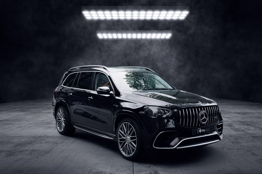 SUV noir de luxe photographié dans un studio sombre, au design imposant et élégant