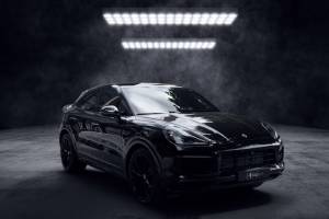 SUV noir au design sportif photographié dans un studio sombre