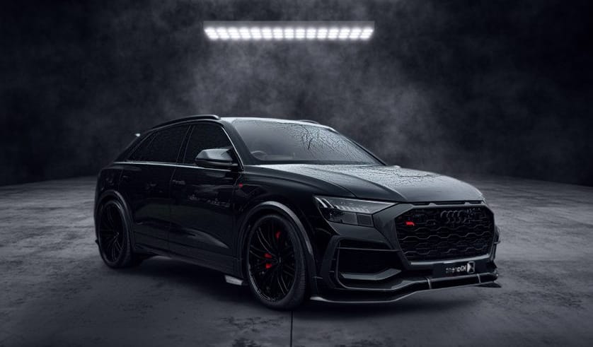 SUV noir sportif photographié dans un studio sombre, au design agressif et élégant