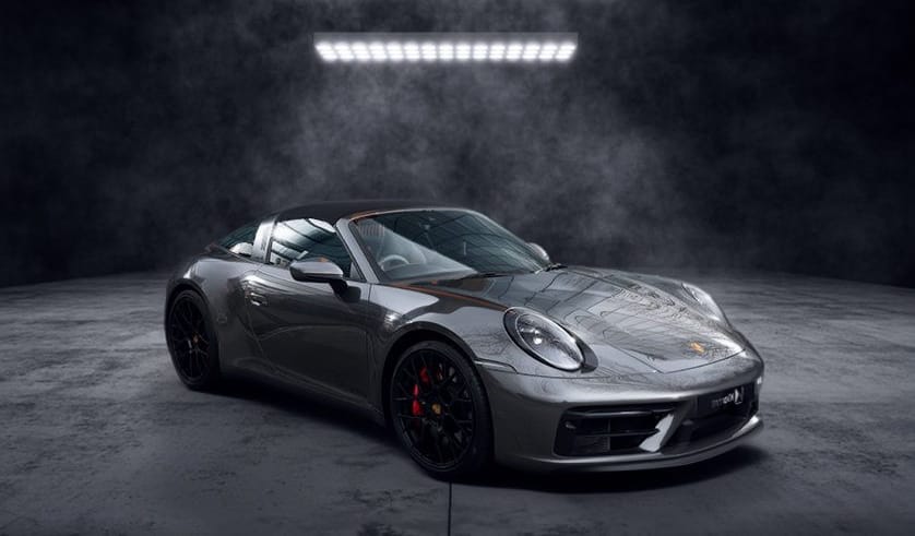 Porsche 911 Targa 4 GTS Type 992 2023 – Collection Évasion Voiture de sport grise décapotable photographiée dans un studio sombre, avec design élégant et moderne