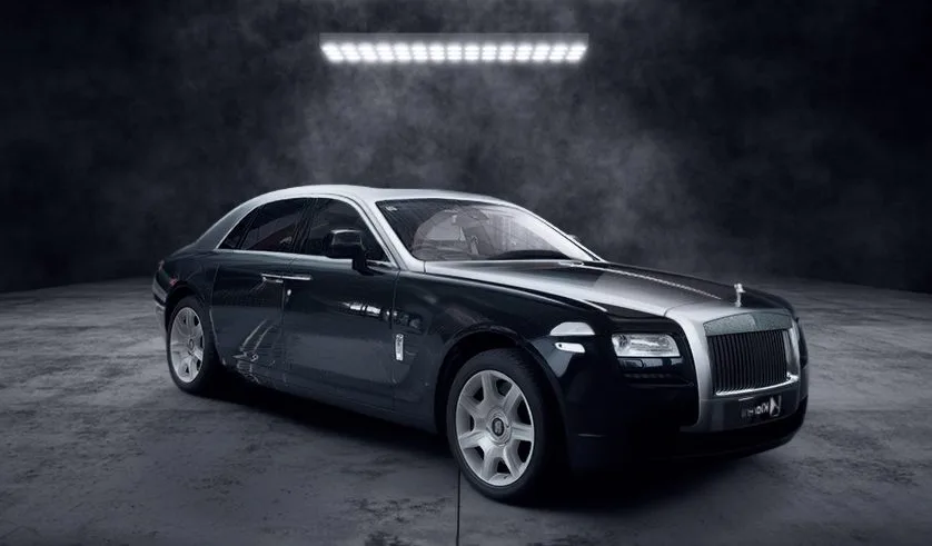 Berline noire et grise photographiée dans un studio sombre, avec design élégant et finitions luxueuses