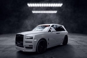 Face avant SUV blanc de luxe photographié dans un studio sombre, avec finitions noires et design imposant