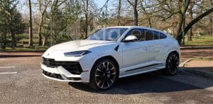 SUV blanc sportif photographié dans un studio sombre, au design moderne et puissant