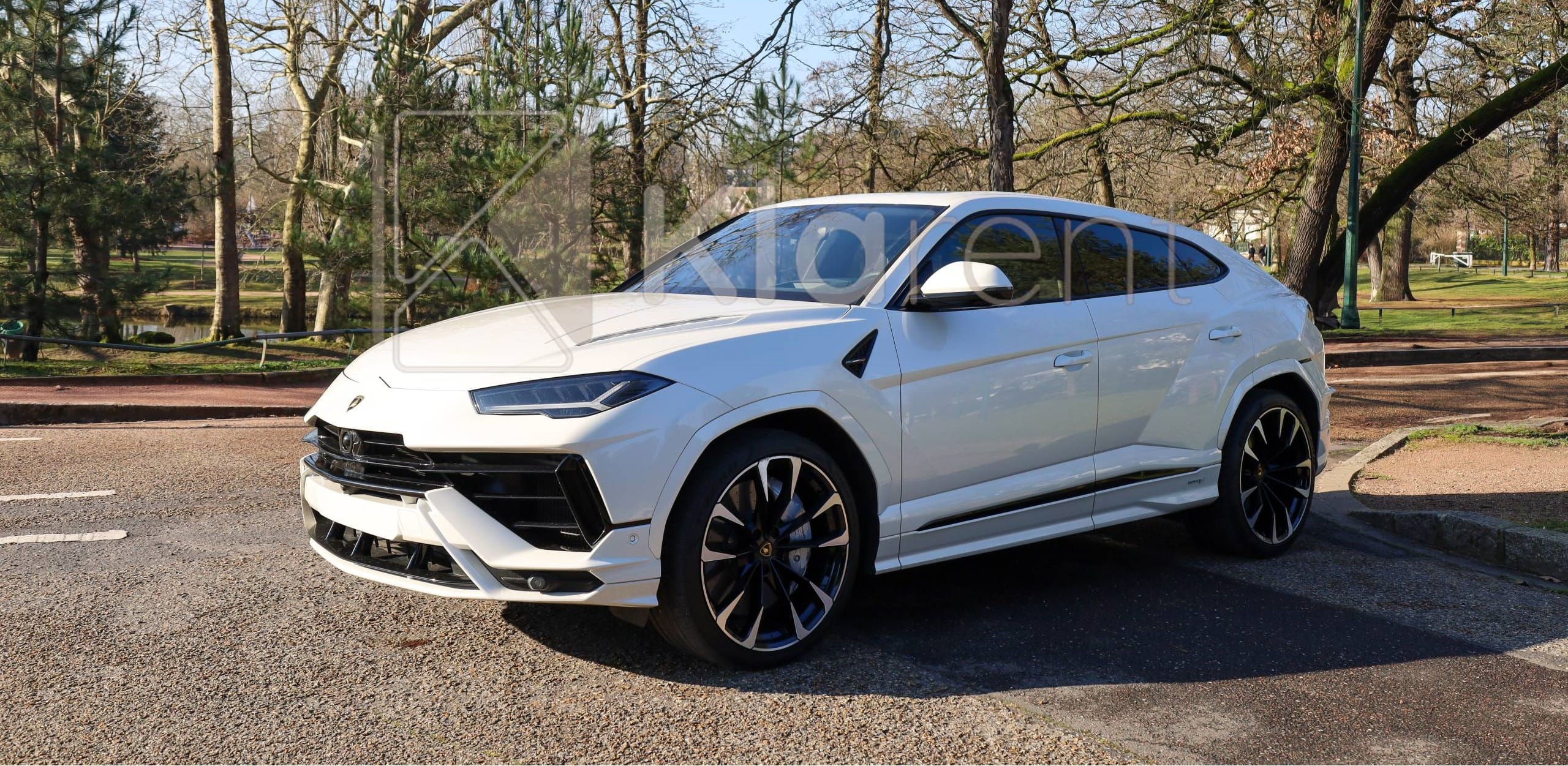 SUV blanc sportif photographié dans un studio sombre, au design moderne et puissant