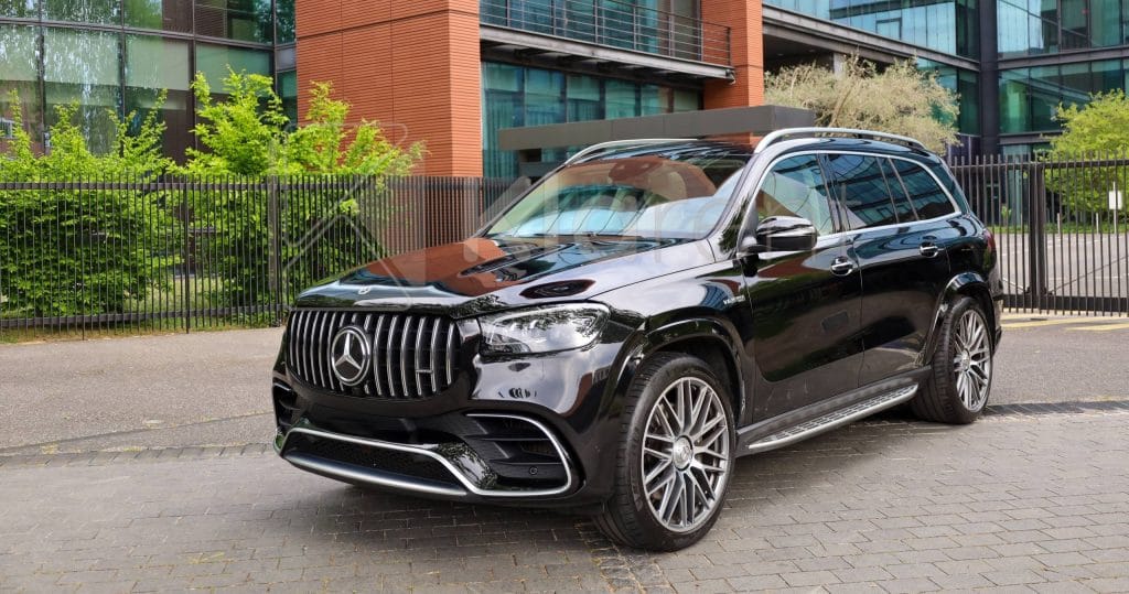 SUV noir de luxe photographié dans un studio sombre, au design imposant et élégant