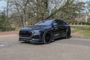 SUV noir sportif photographié dans un studio sombre, au design agressif et élégant