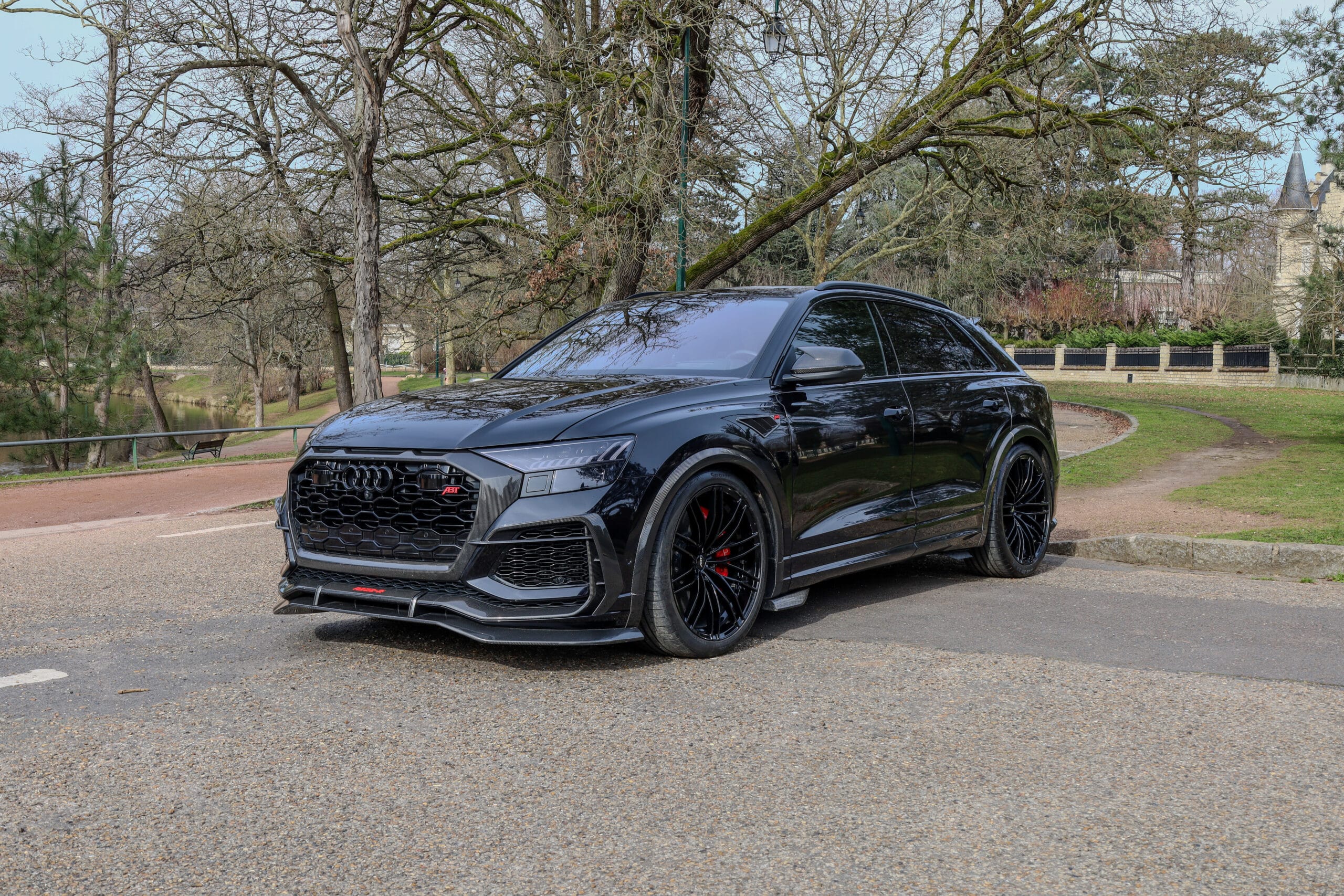 SUV noir sportif photographié dans un studio sombre, au design agressif et élégant